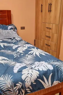 a bedroom with a bed with a blue and white blanket at Cusco Apartment Prime Location in Cusco