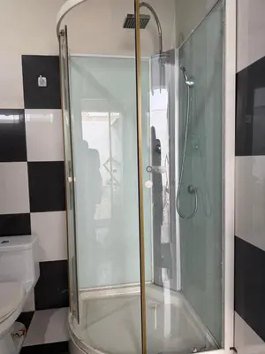 a glass shower in a bathroom with a toilet at Casa de playa in Arica