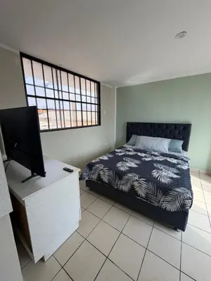 a bedroom with a bed and a flat screen tv at Casa de playa in Arica