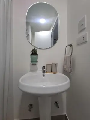 a bathroom with a white sink and a mirror at Cómoda habitación con TV a 20 min del aeropuerto in Lima