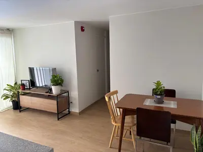 a living room with a dining room table and a television at Cómoda habitación con TV a 20 min del aeropuerto in Lima