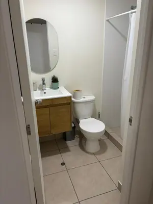 a bathroom with a toilet and a sink and a mirror at Amplia habitación con baño propio a 20 min del aeropuerto in Lima