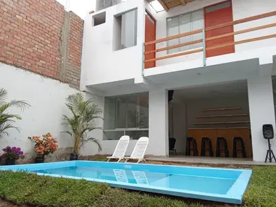 a villa with a swimming pool and two chairs at Excellent house in Quilmana in Quilmaná