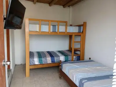 two bunk beds in a room with a flat screen tv at Excellent house in Quilmana in Quilmaná