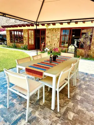 a wooden table and chairs with a table and a table and chairs at Casa de Campo Quives Majestuoso 5BR in Santa Rosa de Quives