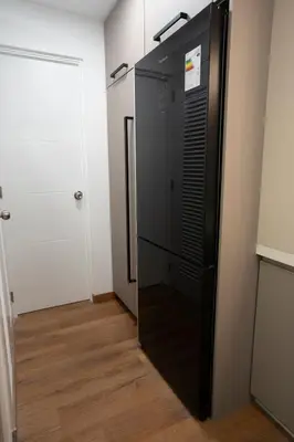 a black refrigerator in a room with a door at Miraflores Prime Apartment - full AC-Kennedy Park in Lima