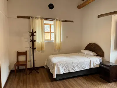 a bedroom with a bed and a window at plaza inn in Ollantaytambo