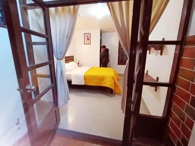 a bedroom with a bed with a yellow blanket at Destinos Peru Inn - Destinos in Machu Picchu