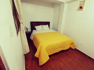 a bedroom with a bed with a yellow blanket at Destinos Peru Inn - Destinos in Machu Picchu