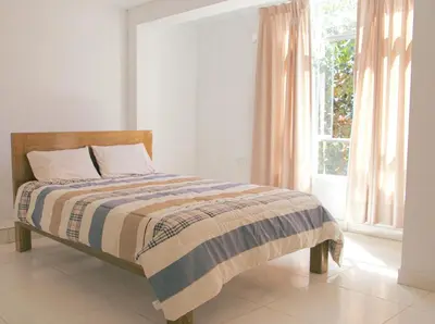 a bed in a white room with a window at Departamento en Ayacucho in Ayacucho