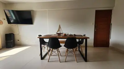a dining room table with four chairs and a television at Apartment in San Bartolo - Playa Norte in San Bartolo