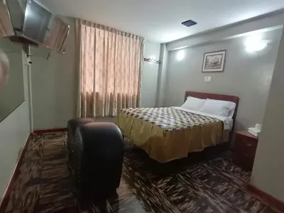 a hotel room with a bed and a television at Kenko in Lima