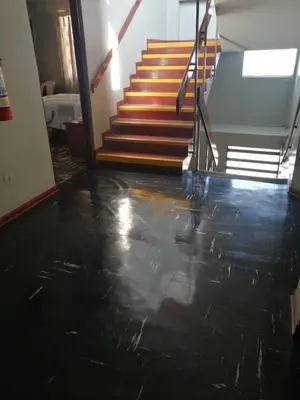 a hallway with a black floor and stairs at Kenko in Lima