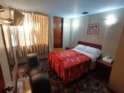 a hotel room with a bed with a red blanket at Kenko in Lima