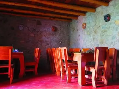 a dining room with wooden tables and chairs at Birds Hotel Molino in Ollantaytambo