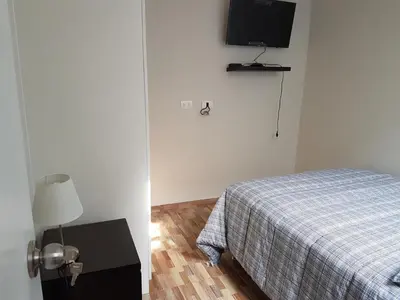 a bedroom with a bed and a tv on the wall at Lima Flats in Lima