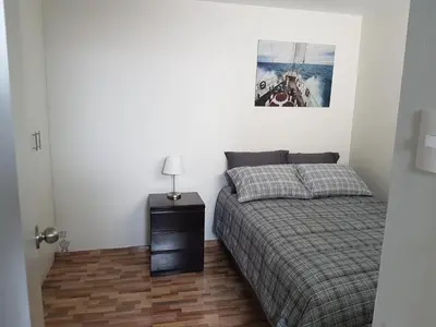 a bedroom with a bed and a lamp on a table at Lima Flats in Lima