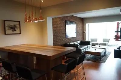 a living room with a large wooden table and chairs at Larcomar Luxury Penthouse in Lima