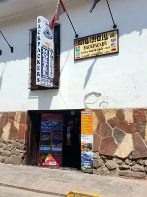 a restaurant with signs on the side of a building at Hostel Imperial BACKPACKER in Cusco