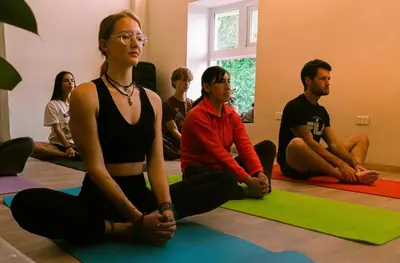 a group of people sitting in a yoga class at Supertramp Hostel Cusco in Cusco