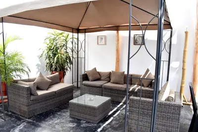 a patio with two couches and an umbrella at Hospedaje El Buen Samaritano in Paracas