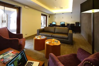 a living room with a couch and a table with a laptop at Hilton Garden Inn Cusco in Cusco