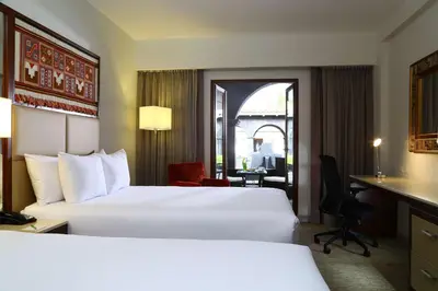 a hotel room with two beds and a desk at Hilton Garden Inn Cusco in Cusco