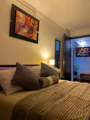 a bedroom with a bed with a painting on the wall at Allincay Cusco Apart Hotel in Cusco