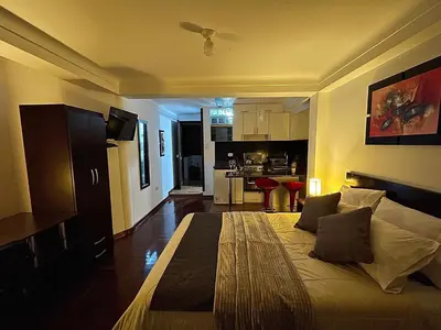 a bedroom with a bed and a living room at Allincay Cusco Apart Hotel in Cusco