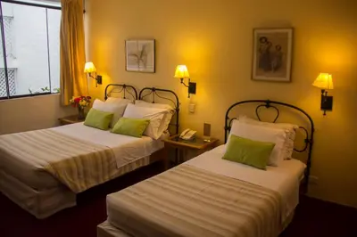 a hotel room with two beds and a phone at El Patio Miraflores in Lima