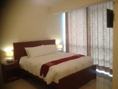 a bedroom with a bed and a window with curtains at Aqua Hotel Cusco in Cusco