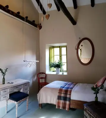 a bedroom with a bed and a table and a mirror at Niños Hotel Fierro in Cusco