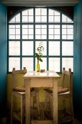 a table with a vase on it in front of a window at Niños Hotel Fierro in Cusco
