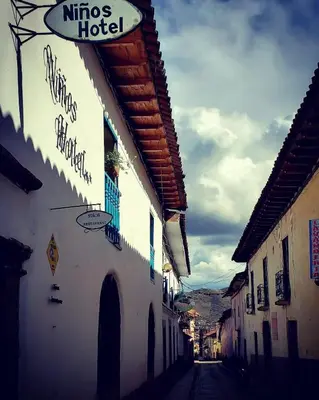 a street with a hotel sign on the side of a building at Niños Hotel Fierro in Cusco