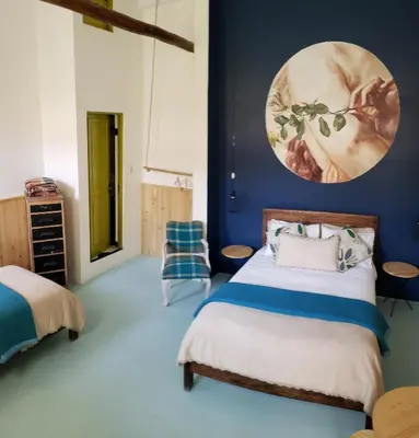 a bedroom with a bed and a blue wall at Niños Hotel Fierro in Cusco