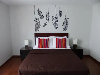 a bedroom with a bed with leaves on the wall at The Lighthouse Bed and Breakfast in Lima