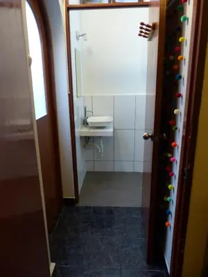 a bathroom with a toilet and a sink and a door at The Lighthouse Bed and Breakfast in Lima