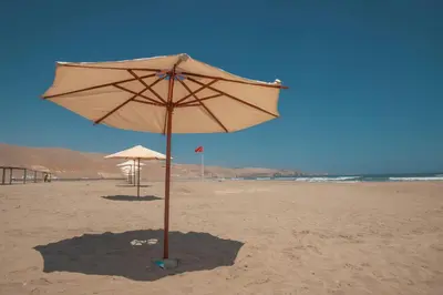 a large umbrella on the beach with a flag at DM Hoteles Asia in Asia