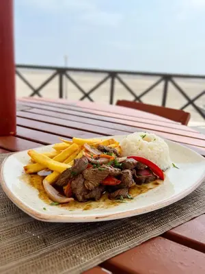 a plate of food with meat and fries on a table at DM Hoteles Asia in Asia