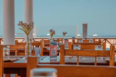 a restaurant with wooden tables and chairs with flowers in vases at DM Hoteles Asia in Asia