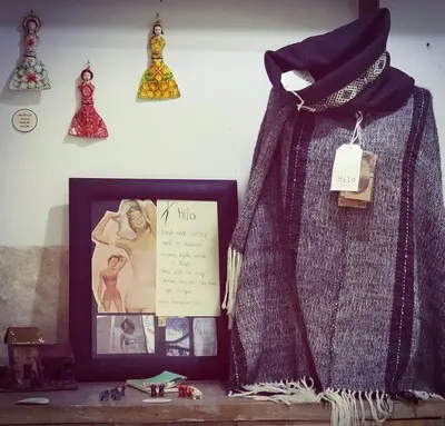 a picture frame on a shelf with a picture of a woman at Niños Hotel Meloc in Cusco