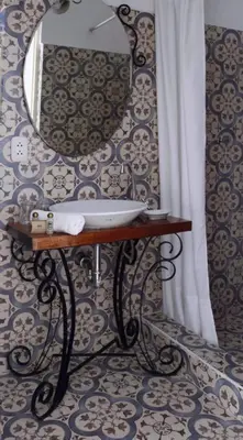 a bathroom with a sink and a mirror on a wall at Niños Hotel Meloc in Cusco