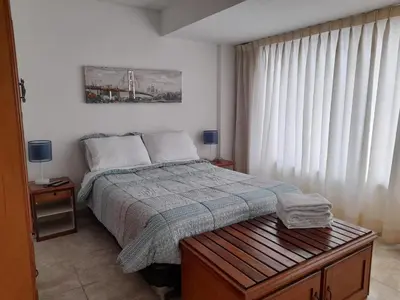 a bedroom with a bed and a table and a window at Hospedaje de Lidia in Lima