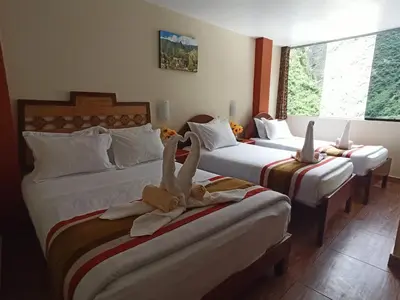 two beds in a hotel room with towels on them at Hostal Vista Waynapata 123 in Machu Picchu