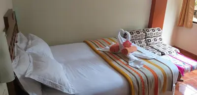 a bedroom with a bed with a stuffed animal on it at Hostal Vista Waynapata 123 in Machu Picchu