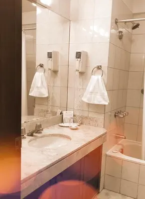 a bathroom with a sink and a mirror and a tub at Hotel Boulevard in Lima
