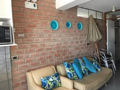a brick wall with a couch and blue pillows at Bungalows Cerro Azul in Cerro Azul