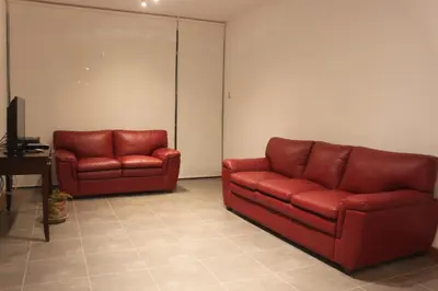 two red leather couches sitting in a room at Caihuayna Apart Hotel in Paracas