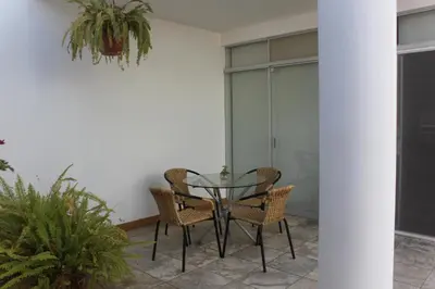 a glass table and chairs on a patio at Caihuayna Apart Hotel in Paracas