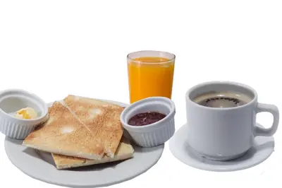 a plate of food with toast and a cup of coffee at Suite Service Apart Hotel in Lima